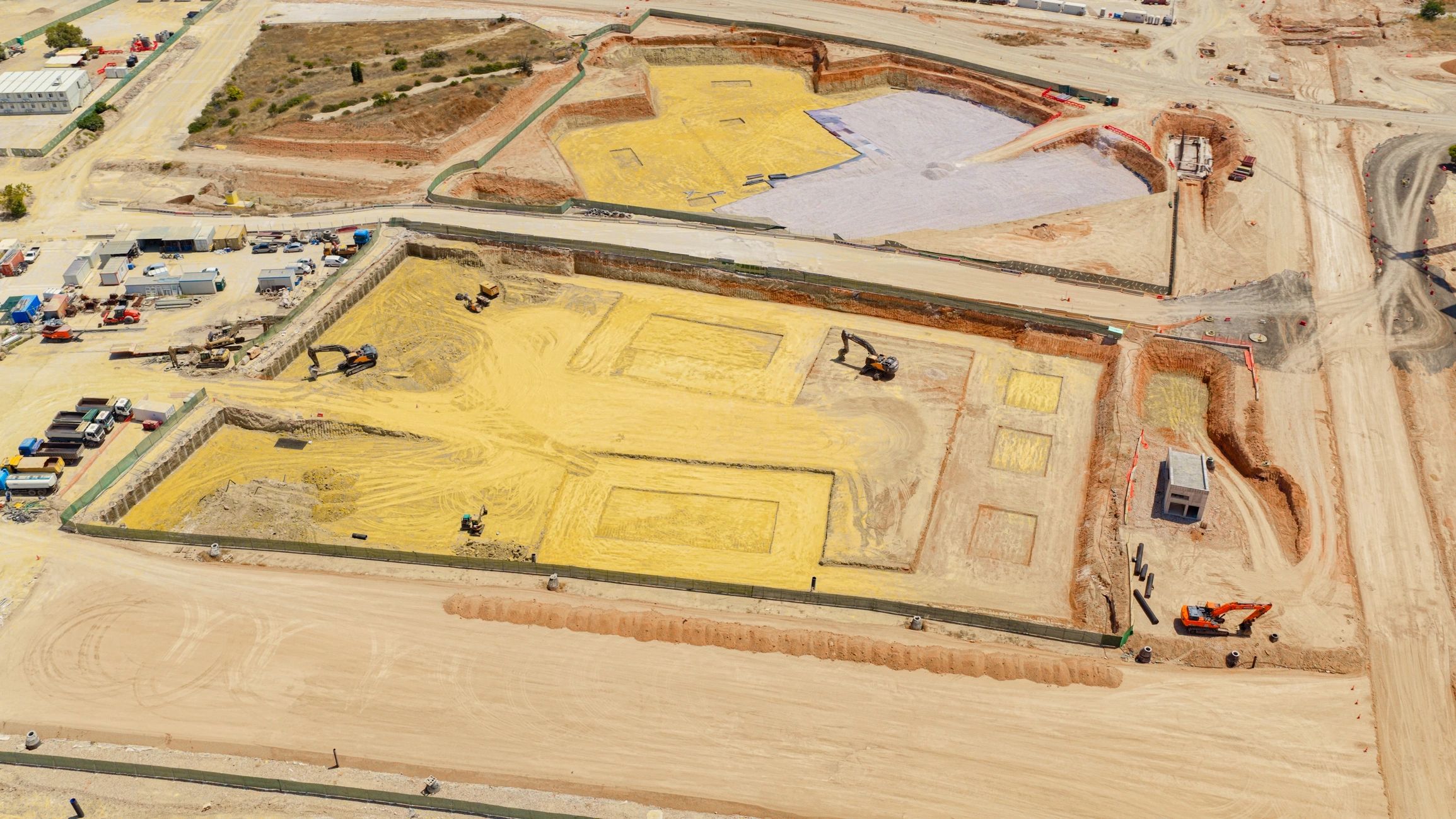 Civil infrastructure earthworks with excavators and prepared foundations